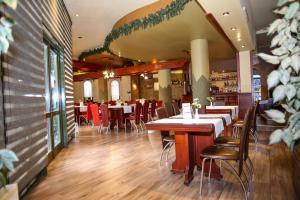 a dining room with tables and chairs in a restaurant at Hotel Silva in Vatra Dornei