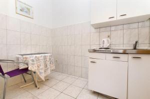a small kitchen with a table and a sink at Apartments Nevenka in Sumpetar