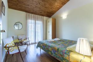 a bedroom with a bed and a chair and a window at Apartment Srecko in Vinišće