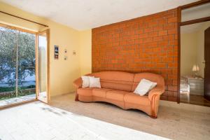 a couch in a room with a brick wall at Apartment Srecko in Vinišće