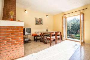 a dining room with a brick wall and a table at Apartment Srecko in Vinišće