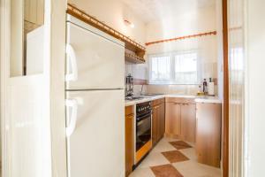 a kitchen with a white refrigerator and wooden cabinets at Apartment Srecko in Vinišće