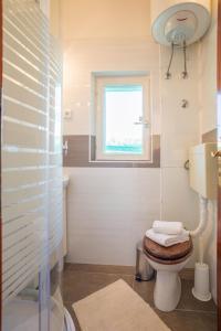 a bathroom with a toilet and a window at Apartment Srecko in Vinišće +30 photos