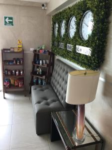 a waiting room with a couch and clocks on the wall at Herbal Inn Suites in Puebla