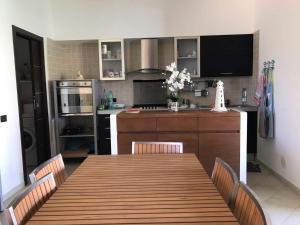 a kitchen with a wooden table and a dining room at Marinagri Resort in Policoro