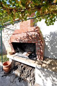 a brick fireplace with a fire place in a yard at Apartment Aljosa in Bol