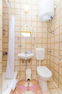 a bathroom with a toilet and a sink at Apartments Kunac in Podgora +50 photos