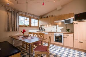 a kitchen with a wooden table and a dining room at Haus Kammerland in Zell am Ziller