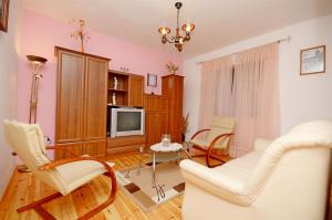 a living room with a couch and chairs and a tv at House Ivan in Prigradica