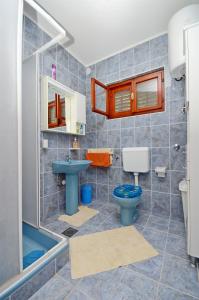 a bathroom with a blue toilet and a sink at House Ivan in Prigradica