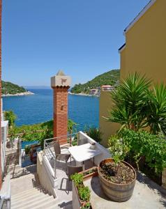 een balkon met een tafel en uitzicht op het water bij Apartments and Rooms Barbara in Lastovo