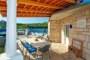 un patio avec une table et des chaises sous un toit dans l'établissement House Ivica, à Korčula