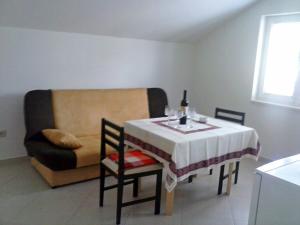 a dining room with a table and a couch at Apartments Mara in Molunat
