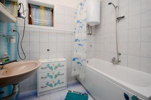 bagno con lavandino, vasca, servizi igienici e lavandino di Apartments Zvonimir a Senj