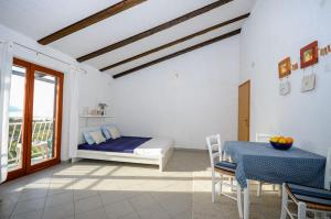 a bedroom with a bed and a table and a window at Apartments Nina in Stinica