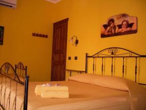 a bedroom with two beds with yellow walls at Le Tre Caravelle in Trabia