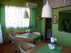 uma sala de jantar com paredes verdes e uma mesa e cadeiras em Le Tre Caravelle em Trabia