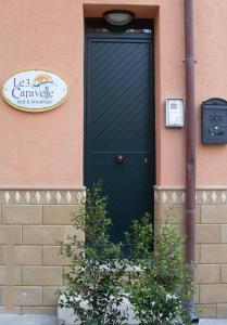 a black door with a sign on a building at Le Tre Caravelle in Trabia