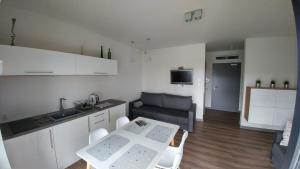 uma cozinha e sala de estar com uma mesa e um sofá em Apartamenty 5 mórz em Sianozety