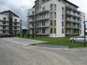 um complexo de apartamentos com carros estacionados num parque de estacionamento em Apartamenty 5 mórz em Sianozety