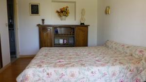 ロシュフォールにあるBoulevard 66のベッドルーム1室(ベッド1台付)、花が飾られたキャビネットが備わります。