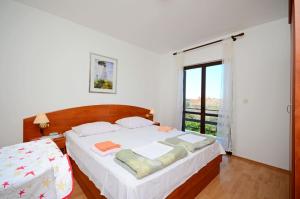 a bedroom with a bed and a large window at Rooms Mande in Banjol