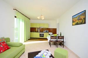 - un salon avec un canapé et une salle à manger dans l'établissement Apartments Ante, à Njivice