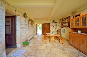 a room with a table and a stone wall at Apartment Srblin in Sveti Petar u Šumi