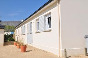 ein weißes Gebäude mit einem Fenster und Topfpflanzen in der Unterkunft Roches Blanches 3 in Saint-Lunaire + 13 Fotos