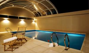 a swimming pool with a chair and a table at Land Plaza Hotel in Bahía Blanca