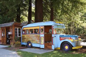 an old bus is parked next to a building at Big Sur River Inn in Big Sur