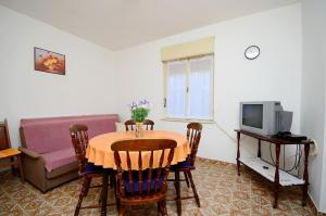 a living room with a table and a tv at Apartments Mirela in Pula