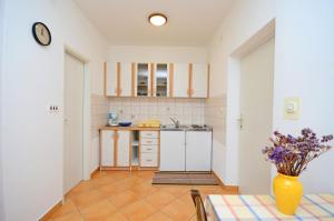 a kitchen with a table and a vase of flowers at Apartments Mirela in Pula