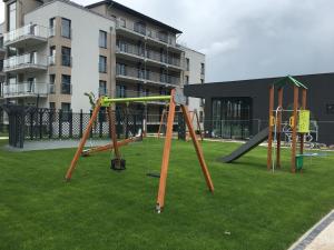 um parque infantil com dois baloiços num parque em Apartamenty 5 mórz em Sianozety