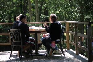 two men sitting at a table on a deck at Big Sur River Inn in Big Sur