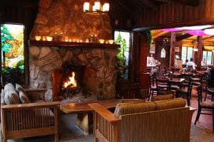 a fireplace in a restaurant with chairs and a table at Big Sur River Inn in Big Sur