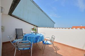 a table with chairs and a blue table cloth on a patio at Apartments Gloria in Vrsar