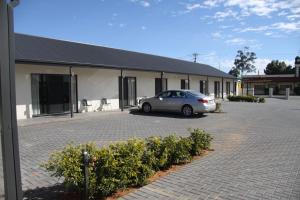 a car parked in a parking lot in front of a building at Red Earth Motel in Broken Hill