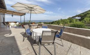 a table and chairs with an umbrella on a patio at Apartment Sanja in Martina