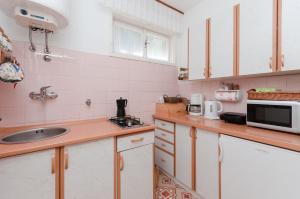 małą kuchnię ze zlewem i kuchenką mikrofalową w obiekcie House Mirella w mieście Mošćenička Draga