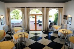 un restaurante con mesas y sillas en una habitación en Hostal de la Costa en Villa Carlos Paz