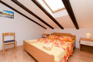 a bedroom with a bed and a chair at Apartment Mauro in Punat