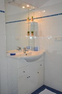 bagno bianco con lavandino e specchio di Appartement Saint-Malo Intra Muros a Saint Malo