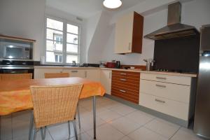 una cucina con tavolo, sedie e frigorifero di Appartement Saint-Malo Intra Muros a Saint Malo