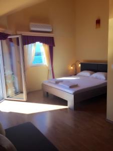 um quarto com uma cama grande e uma janela em Apart hotel Samardzic em Tivat