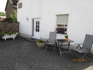 a patio with two chairs and a table and a tub at Ferienwohnung Hück in Lind