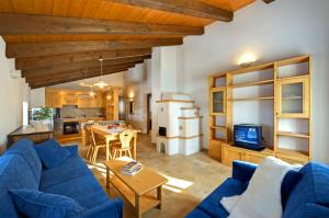 a living room with a blue couch and a kitchen at Albergo Diffuso Sauris in Lateis in Lateis