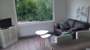 a living room with a couch and a table and a window at Minicamping Wisse in Meliskerke