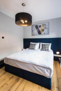 ein Schlafzimmer mit einem großen Bett mit zwei Kissen in der Unterkunft Bella - Victoria Residence by OneApartments in Sopot