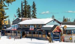 
a person standing in front of a cabin on a ski slope at The Bulldog Hotel in Silver Star
